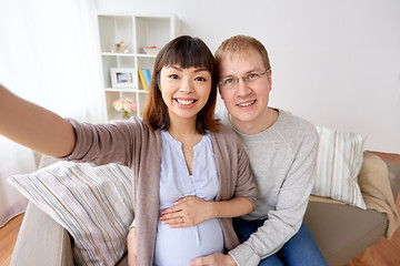 Image showing pregnant woman with husband taking selfie at home