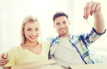 Image showing happy couple with key and boxes moving to new home