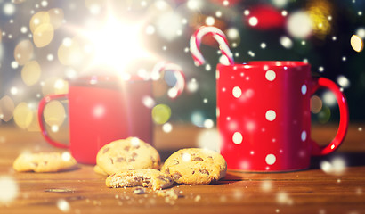 Image showing christmas candy canes and cups on wooden table