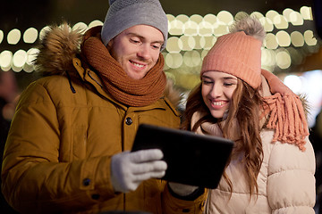 Image showing happy couple with tablet pc at christmas market