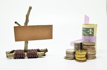 Image showing Paper sign board with stack of coins