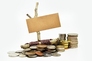 Image showing Paper sign board with stack of coins