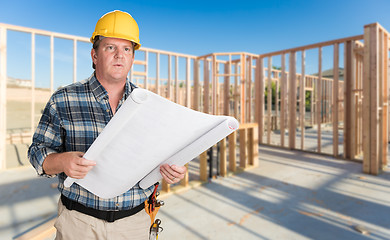 Image showing Male Contractor With House Plans Wearing Hard Hat Inside New Hou