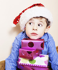 Image showing little cute boy with Christmas gifts at home. close up emotional