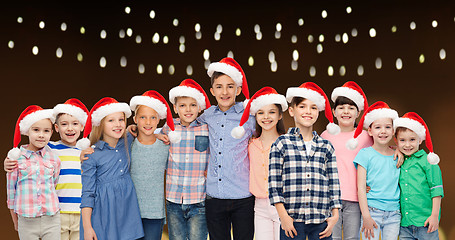 Image showing happy smiling children in christmas santa hats