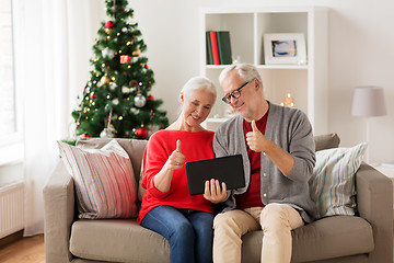 Image showing happy senior couple with tablet pc at christmas