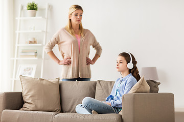 Image showing girl with earphones and angry mother at home