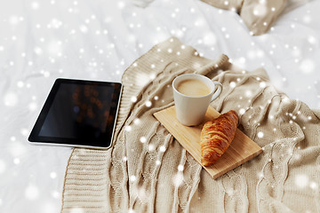 Image showing tablet pc, coffee and croissant on bed at home