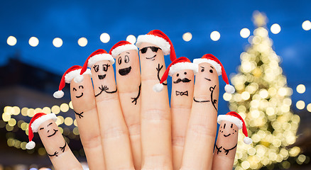 Image showing fingers in santa hats over night lights background