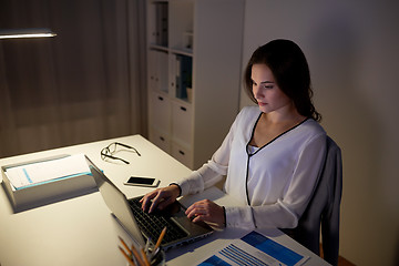 Image showing businesswoman typing on laptop at night office