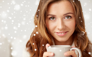 Image showing close up of happy woman with coffee cup over snow