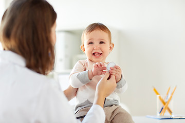Image showing happy doctor or pediatrician with baby at clinic