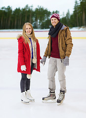 Image showing happy couple holding hands on skating rink