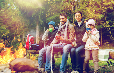 Image showing happy family sitting on bench at camp fire