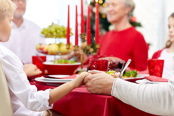 Image showing family having holiday dinner and praying at home