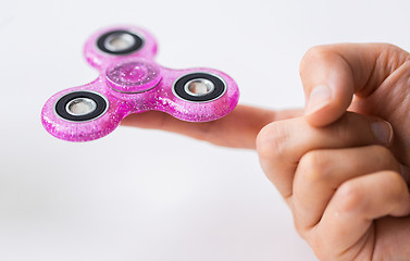 Image showing close up of hand playing with fidget spinner