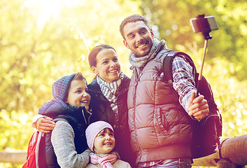 Image showing happy family with smartphone selfie stick at camp