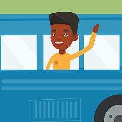 Image showing African-american man waving hand from bus window.