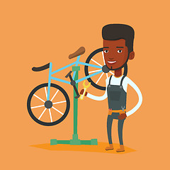 Image showing African bicycle mechanic working in repair shop.