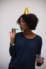 Image showing black woman in party hat blowing in whistle