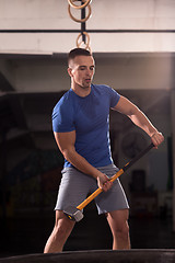 Image showing man workout with hammer and tractor tire