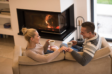 Image showing Young couple  in front of fireplace