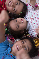 Image showing kids  blowing confetti while lying on the floor