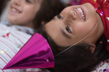 Image showing kids  blowing confetti while lying on the floor