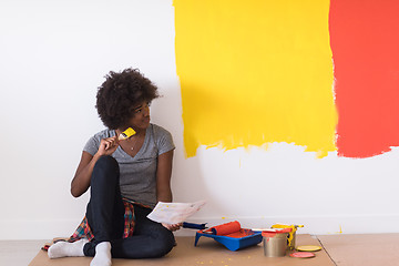 Image showing back female painter sitting on floor