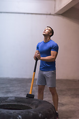 Image showing man workout with hammer and tractor tire