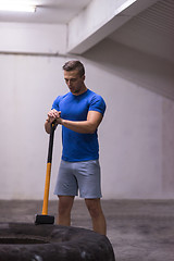 Image showing man workout with hammer and tractor tire