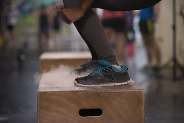 Image showing black woman is performing box jumps at gym