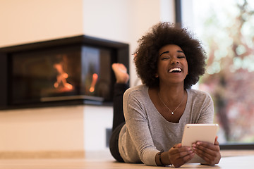 Image showing black women using tablet computer on the floor