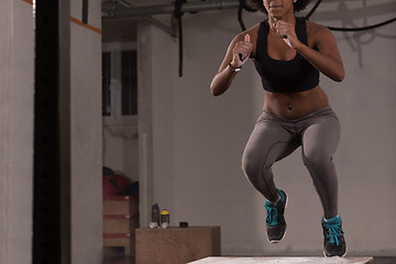 Image showing black woman is performing box jumps at gym
