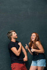 Image showing Beautiful woman impressed by the muscles of a bodybuilder, strong man showing off his muscles