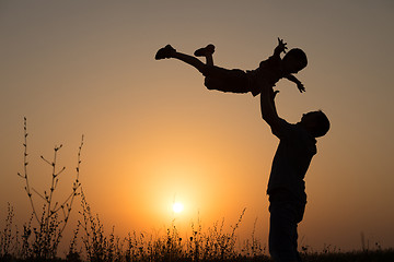 Image showing Father and son playing in the park at the sunset time.