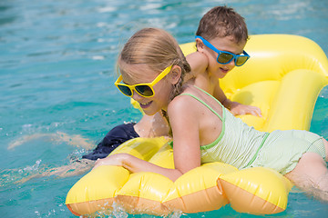 Image showing Two happy children playing on the swimming pool at the day time.