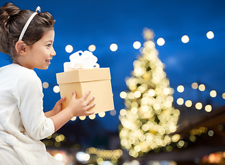 Image showing happy girl with gift box over christmas lights
