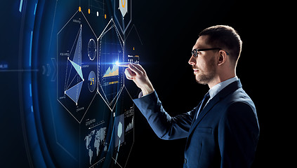Image showing businessman working with charts on virtual screen