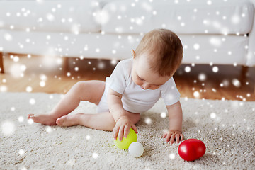 Image showing happy baby playing with balls on floor at home