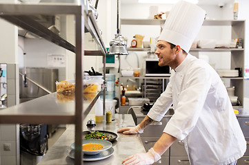 Image showing happy male chef cooking food at restaurant kitchen