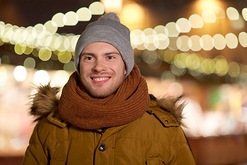 Image showing happy young man over christmas lights in winter