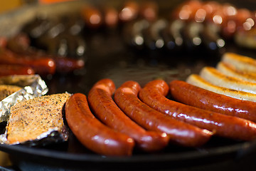 Image showing sausages and salmon frying in stir fry pan