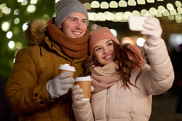 Image showing couple with coffee taking selfie at christmas