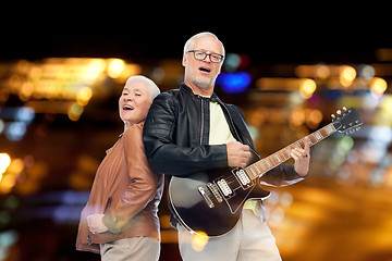 Image showing happy senior couple with electric guitar singing