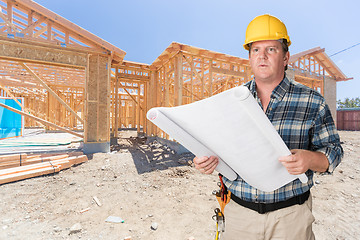 Image showing Male Contractor With House Plans Wearing Hard Hat In Front of Ne