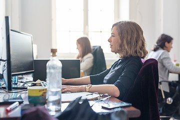 Image showing Yound devoted female software developers team working on desktop computer in IT statup company.