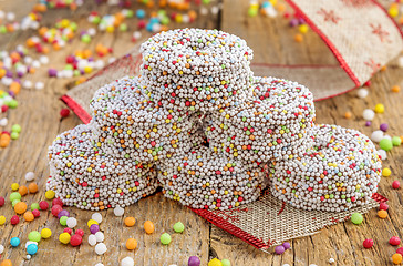 Image showing Colored chocolate rings with Christmas decoration on wood