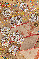 Image showing Colored chocolate rings with Christmas decoration on wood