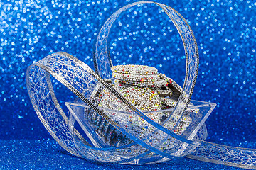 Image showing Colored chocolate rings in bowl with Christmas decoration on blu